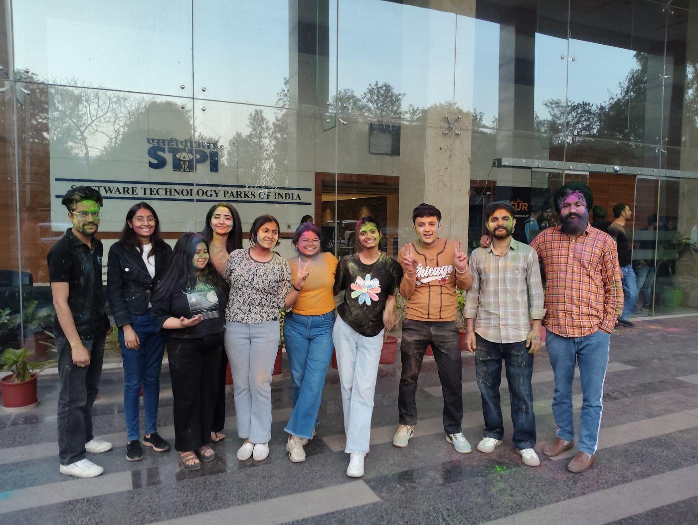 Team covered in colours outside the office for Holi